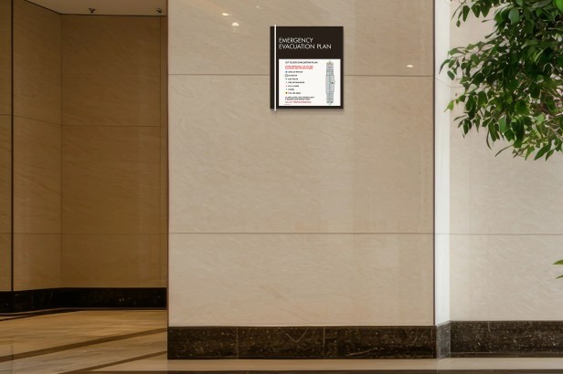 A close-up of a Midtown evacuation map or plan holder mounted on a wall, revealing a detailed emergency evacuation plan inside.