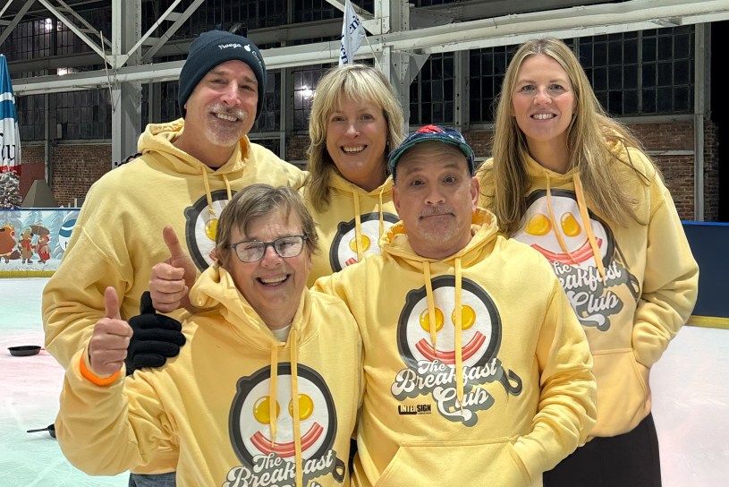 EvacuationPlans.com team smiling together at the Skillet Curling Tournament, raising funds for local hunger relief.