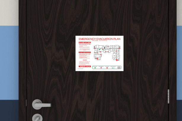 An emergency evacuation plan mounted on a dark wood door, featuring clear fire instructions, exit routes, extinguishers, and stair locations. The map includes bold red and green life-safety symbols and a detailed floor layout, providing a code-aligned evacuation overview for multi-unit facilities.